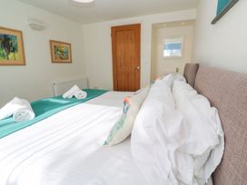 A bedroom with a bed and framed paintings at Five Elements Barn in Truro