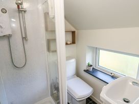 A bathroom with a shower, toilet, and sink at Five Elements Barn in Truro
