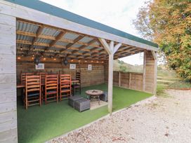An outdoor dining area with tables and chairs at Five Elements Barn, St Agnes