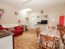 A kitchen with a table and chairs and a sofa at Kate's Cottage
