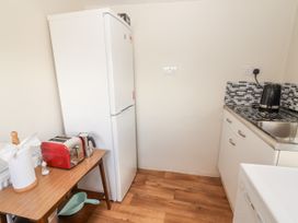 A kitchen with a refrigerator, toaster, and sink at Kate's Cottage