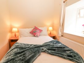 A bedroom with a bed and bedside tables at Kate's Cottage