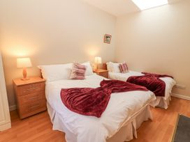 A bedroom with two beds and nightstands at Kate's Cottage
