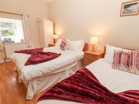 A bedroom with two beds and a window at Kate's Cottage