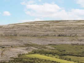 Landscape with hills and rock formations under a cloudy sky at Kate's Cottage