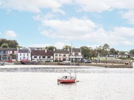 A boat on water with buildings and trees at Kate's Cottage