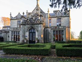 An exterior view of a building with hedges at Summerlands Hall Apartment