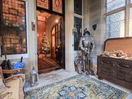 An entrance hall with a christmas tree and suit of armour at Summerlands Hall Apartment