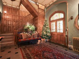 An entrance hall with a staircase and sitting area at Summerlands Hall Apartment