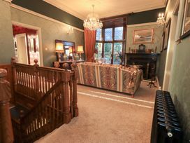 A living room with a sofa and chandelier at Summerlands Hall Apartment
