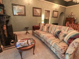 A living room with a sofa and table at Summerlands Hall Apartment