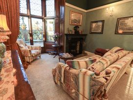 A living room with a sofa and lamp at Summerlands Hall Apartment