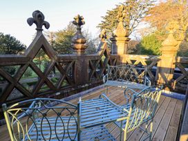 An outdoor terrace with a balustrade and seating at Summerlands Hall Apartment