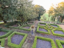 A garden with hedges and gravel pathways at Summerlands Hall Apartment