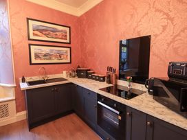 A kitchen with cabinets and appliances at Summerlands Hall Apartment