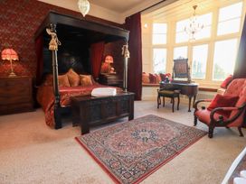 A bedroom with a canopy bed and window seating at Summerlands Hall Apartment