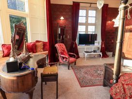 A living room with a television and seating at Summerlands Hall Apartment