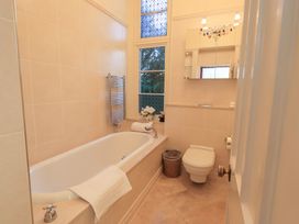 A bathroom featuring a bathtub and toilet at Summerlands Hall Apartment