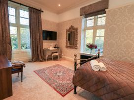 A bedroom with a bed and television at Summerlands Hall Apartment 