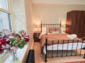 A bedroom with a bed and bedside tables at Summerlands Hall Apartment