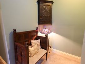 A small seating area with a bench and decorative lamp at Summerlands Hall Apartment