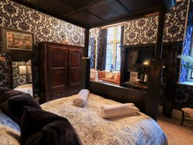 A bedroom with a four-poster bed and wardrobe at Summerlands Hall Apartment