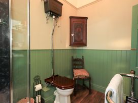 A bathroom with a toilet, sink, and shower at Summerlands Hall Apartment