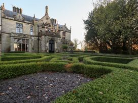 A garden with hedges and pathways at Summerlands Hall Apartment