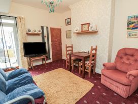 A living room with a sofa, armchair, and dining table at 170 Victoria Road