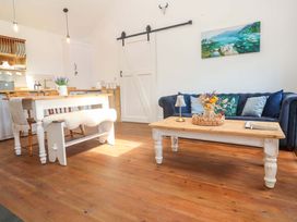 A living room with a sofa table and dining area at Lavender Cottage