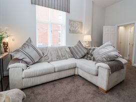 A living room with a sofa and lamp at No 2 Emporium Apartments in Prestatyn