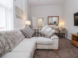 A living room with a sofa and a dining table at No 2 Emporium Apartments Prestatyn