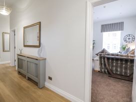 A hallway with a console table and a view of a living room at No 2 Emporium Apartments in Prestatyn