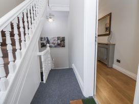 A hallway with a staircase and a console table at No 2 Emporium Apartments in Prestatyn