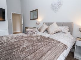 A bedroom with a bed and a mirror at No 2 Emporium Apartments in Prestatyn