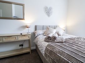 A bedroom with a bed and a console table at No 2 Emporium Apartments in Prestatyn