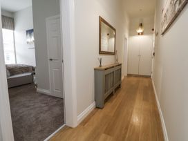 A hallway with a mirror and a storage cabinet at No 2 Emporium Apartments Prestatyn