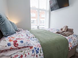 A bedroom with a bed and tv at No 2 Emporium Apartments in Prestatyn