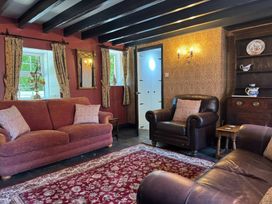 A living room with sofas and a rug at St. James Cottage in Liskeard