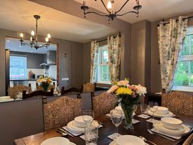 A dining room with a table set for meals at St. James Cottage Liskeard