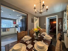A dining room with a table set for dinner at St. James Cottage in Liskeard