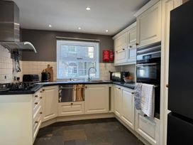 A kitchen with appliances and a window at St. James Cottage in Liskeard