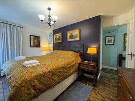 A bedroom with a bed and nightstand at St. James Cottage in Liskeard