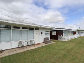 A view of a property with seating area and multiple cabins at 66 Cherry Park in Skegness