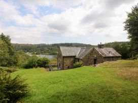 A stone house with a garden near a lake at Ty Newydd Llanrhychwyn near Llanrwst