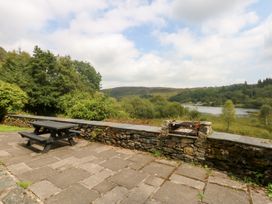 An outdoor area with a table and seating at Ty Newydd in Llanrhychwyn near Llanrwst
