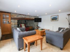 A living room with a sofa and coffee table at Ty Newydd Llanrhychwyn near Llanrwst