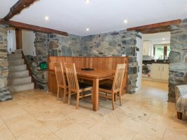 A dining area with a table and chairs at Ty Newydd Llanrhychwyn near Llanrwst