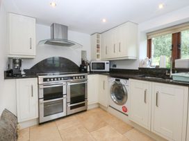 A kitchen with a stove and microwave at Ty Newydd Llanrhychwyn near Llanrwst