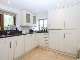 A kitchen with cabinets and a sink at Ty Newydd Llanrhychwyn near Llanrwst